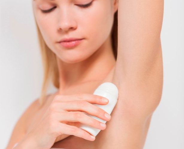 Woman applying deodorant
